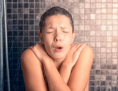Woman taking cold shower